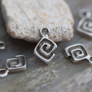 Puede incluir: Pendientes de plata con un dise&ntilde;o en espiral. Los colgantes son de forma cuadrada con esquinas redondeadas. Los colgantes tienen un agujero en la parte superior para sujetarlos a una cadena o pulsera.