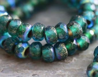 May include: Close-up of a strand of iridescent teal and gold-flecked beads. The beads have a faceted, irregular shape, and are strung together. The beads are approximately 0.5 cm in diameter. The overall theme is jewelry making.