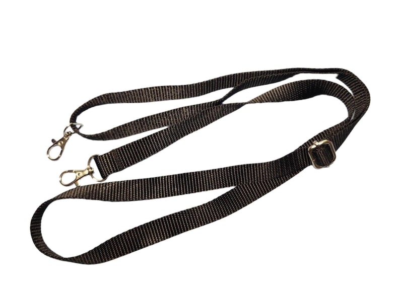 May include: A black adjustable strap with two silver clasps and a silver buckle.
