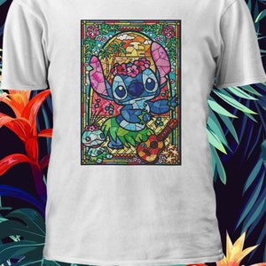 Pu&ograve; includere: Una maglietta bianca con un'immagine di Stitch di Lilo & Stitch che suona l'ukulele in stile vetrata. Stitch indossa una collana di fiori ed &egrave; circondato da piante tropicali e un tramonto.