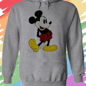 May include: A gray hooded sweatshirt with a vintage-style image of Mickey Mouse in black, red, and yellow. Mickey Mouse is smiling and has his hands on his hips.