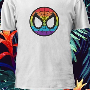 Puede incluir: Camiseta blanca con un logotipo de Spider-Man de colores arco&iacute;ris. El logotipo es un c&iacute;rculo con una telara&ntilde;a negra y una cara de ara&ntilde;a blanca.