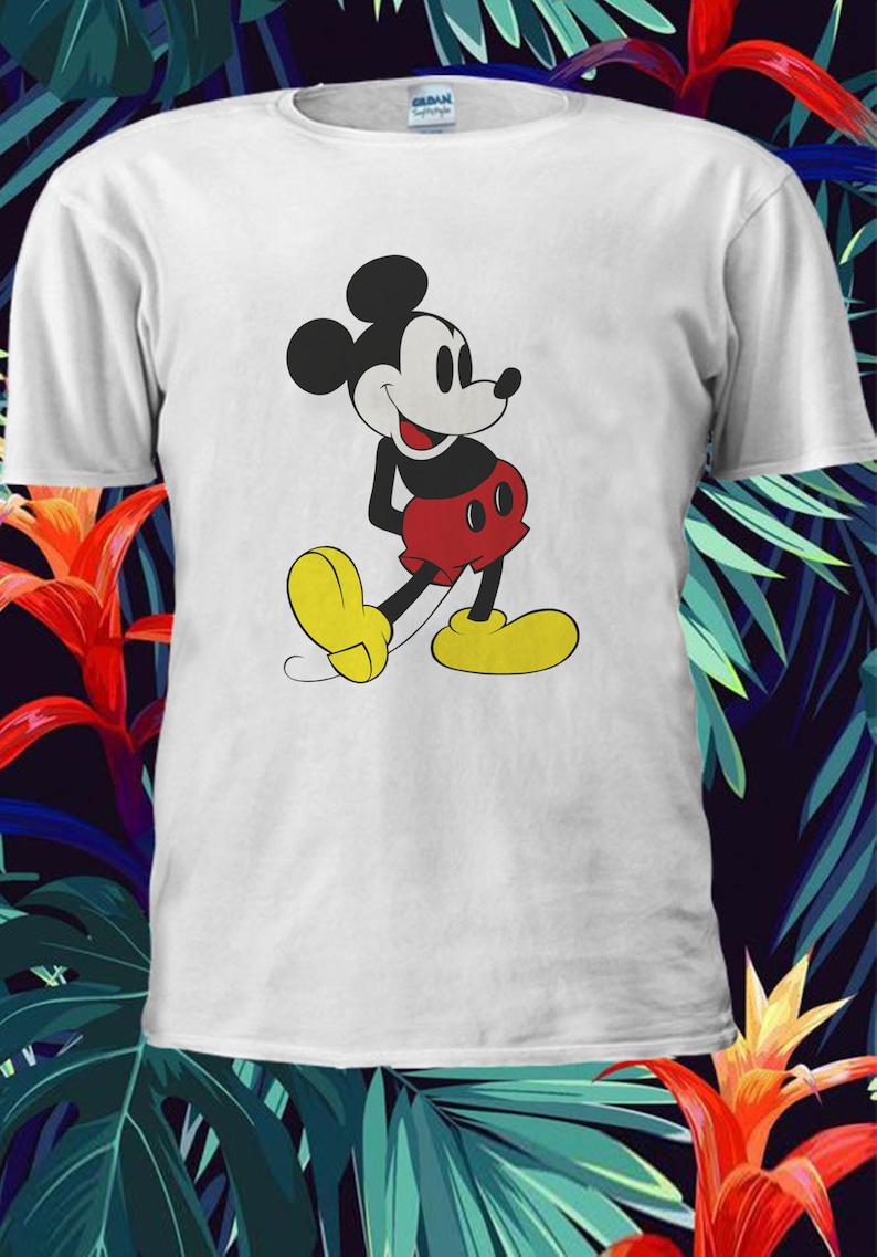 May include: White t-shirt with a cartoon image of Mickey Mouse in a red and black outfit. Mickey Mouse is smiling and walking with his arms at his sides.