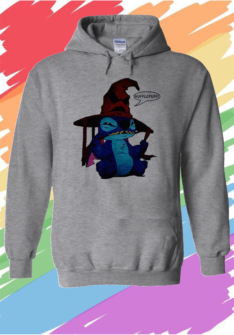 May include: A gray hooded sweatshirt with a blue Stitch character wearing a red and black wizard hat. The hat has a pointed top and a wide brim. The character is holding a wand in its right hand and has a speech bubble above its head that says "Hufflepuff!"