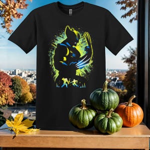 May include: Black t-shirt featuring a colourful graphic of Wolverine from the X-Men. The graphic depicts Wolverine in a fighting stance with his claws extended.
