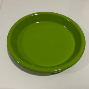 May include: A bright green ceramic saucer for a plant pot.