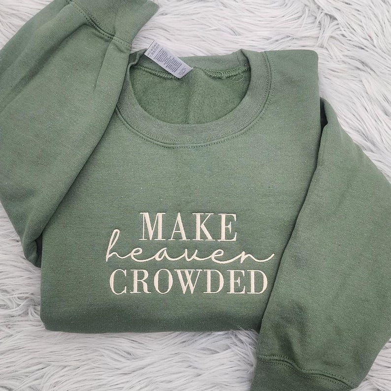 May include: A green sweatshirt with the text "MAKE heaven CROWDED" printed in white on the front.