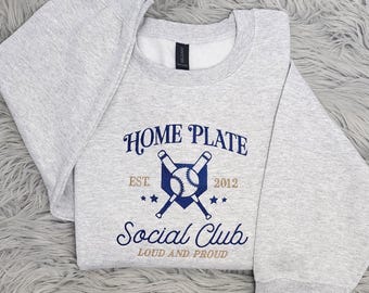 May include: Gray sweatshirt with a navy blue graphic of crossed baseball bats and a ball with the text "Home Plate Est. 2012 Social Club Loud and Proud"