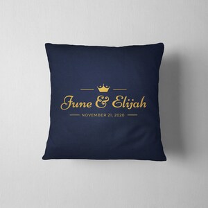 May include: A navy blue throw pillow with a gold crown and the text "June & Elijah" and "NOVEMBER 21, 2020".