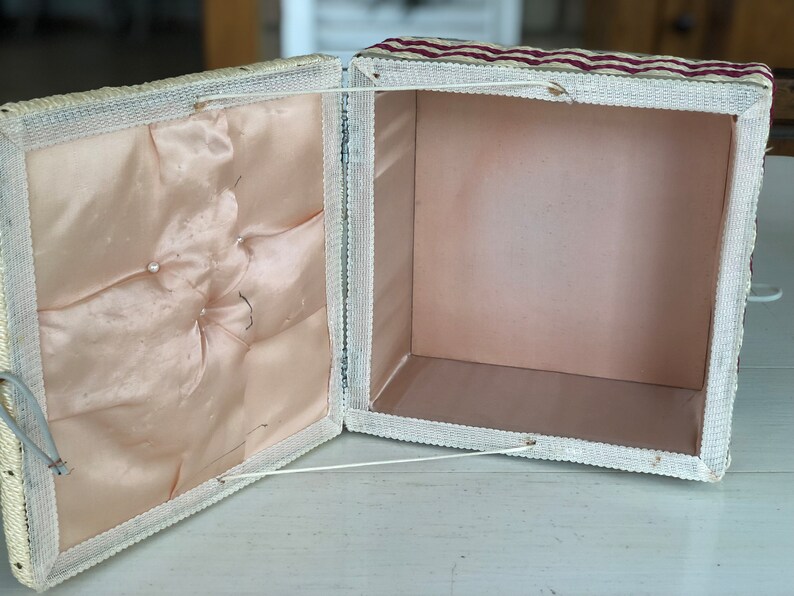 May include: A white and red striped fabric box with a white satin lining. The box is open and the lid is folded back.