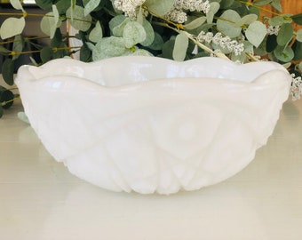 Può includere: Una ciotola in vetro di latte bianco con un bordo smerlato e un design testurizzato e ondulato.
