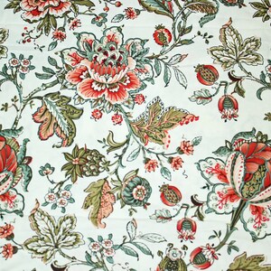 Peut inclure: Un tissu blanc avec un motif floral rouge, vert et rose qui se répète. Le tissu a un aspect et une sensation vintage.