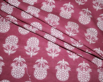 May include: A close-up of a pink fabric with a white floral pattern. The fabric is folded in half and the pattern is visible on both sides.