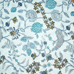 May include: A white fabric with a blue and brown floral pattern. The pattern features stylised flowers, leaves, and vines.