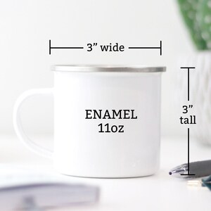 May include: White enamel mug with a black handle. The mug is 3 inches wide and 3 inches tall. It says "ENAMEL 11oz" on the front.