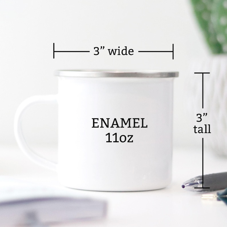 Puede incluir: Taza de esmalte blanco con borde plateado, 7,6 cm de ancho y 7,6 cm de alto, con la palabra "ENAMEL" y "11oz" impresas. La taza tiene un asa blanca y est&aacute; sobre una superficie blanca.