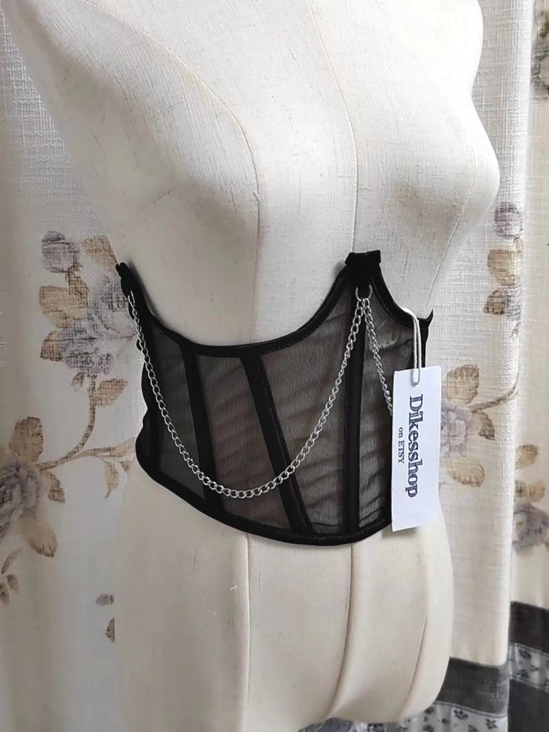 K&ouml;nnte beinhalten: Schwarzes Mesh-Korsett mit silbernem Kettendetail und einem wei&szlig;en Etikett mit der Aufschrift "Dikessshop on Etsy".