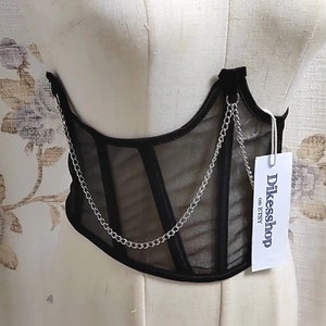 K&ouml;nnte beinhalten: Schwarzes Mesh-Korsett mit silbernem Kettendetail. Das Korsett hat ein Etikett mit der Aufschrift "Dikessshop on Etsy".