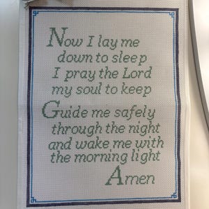 May include: A white needlepoint canvas featuring the embroidered text Now I lay me down to sleep I pray the Lord my soul to keep Guide me safely through the night and wake me with the morning light Amen in green with a blue border.