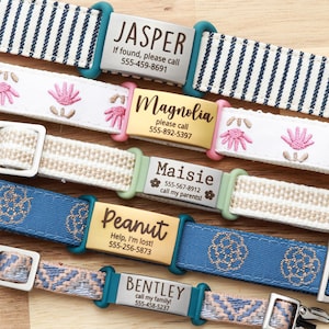 May include: A collection of personalized dog collars with various designs and names. The collars feature text that reads "JASPER", "Magnolia", "Maisie", "Peanut", and "BENTLEY", along with contact information. The collars are in different colors and patterns.