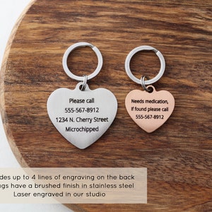 May include: Two heart-shaped pet ID tags with key rings. The silver tag reads "Please call 555-567-8912 1234 N. Cherry Street Microchipped". The rose gold tag reads "Needs medication, If found please call 555-567-8912".