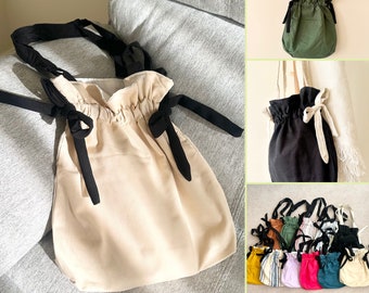 May include: A set of 10 drawstring bags in various colours and patterns. The bags are made of a soft, canvas-like material and have a gathered top with a drawstring closure. The bags are ideal for carrying small items such as makeup, toiletries, or snacks.
