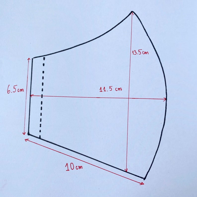 May include: A black and white line drawing of a face mask pattern with measurements in centimetres. The pattern includes a 13.5 cm tall curved top, a 10 cm wide bottom, and a 14.5 cm wide middle section.