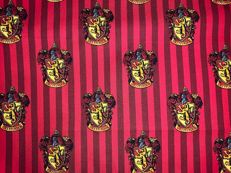 May include: Red and gold fabric with a repeating pattern of the Gryffindor house crest from the Harry Potter series. The crest features a lion, a castle, and the words "Gryffindor" in a banner.