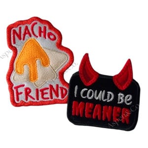 May include: Two embroidered patches. One is shaped like a nacho chip with the words "NACHO FRIEND" and a yellow cheese design. The other is a black rectangle with red devil horns and the words "I COULD BE MEANER".