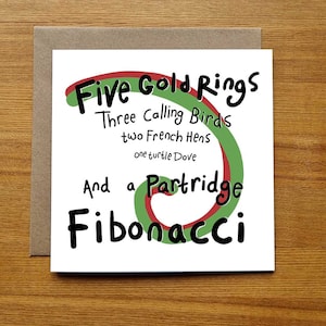 May include: A white card with a green and red swirl design. The card has black text that reads "Five Gold Rings, Three Calling Birds, two French Hens, one turtle Dove, And a Partridge Fibonacci".