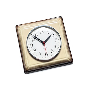 Puede incluir: Un reloj de cuarzo cuadrado con esfera color crema y números negros. El reloj tiene manecillas negras con un segundero rojo, sobre un fondo blanco. El reloj está enmarcado en un marco cuadrado con borde marrón.