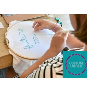 May include: A white t-shirt in an embroidery hoop with the words "future mrs" stitched in teal thread. A person is shown embroidering the shirt. A teal and purple custom order graphic is in the lower right corner.
