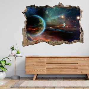 May include: A 3D wall decal depicting a colourful galaxy scene with a large planet and rings, stars, and a nebula. The decal is designed to look like a hole in the wall, creating a realistic 3D effect.
