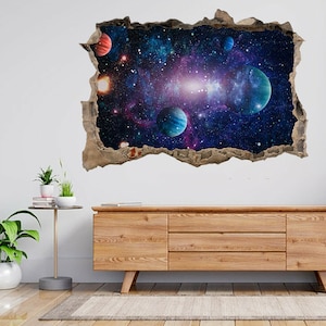 May include: A 3D wall decal depicting a colourful galaxy scene with planets and stars. The decal is designed to look like a hole in the wall, creating a realistic and immersive effect.