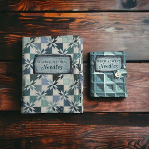 May include: Two fabric needle cases with patchwork designs. The larger case reads "SEWING MACHINE Needles" on a label. The smaller case reads "HAND SEWING Needles" and has a button closure. The cases are in shades of blue, green, and white.