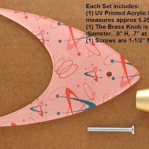 May include: A mid-century modern style cabinet hardware set. Includes a pink acrylic backplate with a retro design, a brass knob, and a screw. The backplate measures approximately 5.25"W x 4"H.