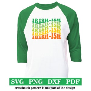 Puede incluir: Una camiseta de b&eacute;isbol blanca con mangas verdes. La camiseta tiene un dise&ntilde;o gr&aacute;fico de la palabra "IRISH-ISH" repetida en un patr&oacute;n de arco&iacute;ris.