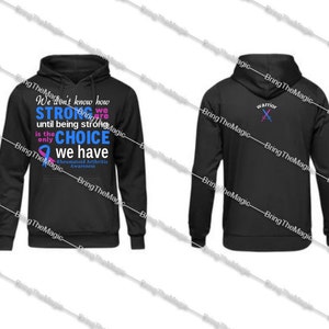 May include: Black hooded sweatshirt with a blue and pink ribbon and the text "We don't know how STRONG we are until being strong is the only CHOICE we have Rheumatoid Arthritis Awareness". The back of the sweatshirt has a pink and blue sword design with the word "warrior".