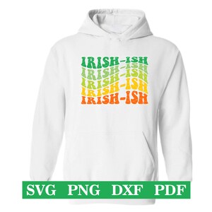 Puede incluir: Sudadera con capucha blanca con un estampado gr&aacute;fico verde, amarillo y naranja que dice "Irish-ish" repetido cinco veces.