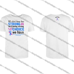 May include: White t-shirt with a blue and pink ribbon and the text "We don't know how STRONG we are until being strong is the only CHOICE we have Rheumatoid Arthritis Awareness". The back of the shirt has the word "warrior" and two crossed swords.