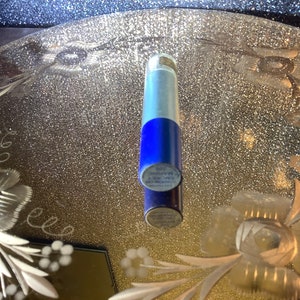 Può includere: Un tubo argentato e blu con il testo "Long Lasting" e "A New Way To" stampato sul lato.