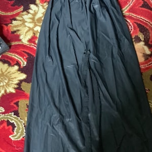 May include: A black slip skirt with a lace trim. The skirt has a slit up the front.