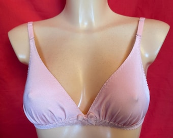 May include: A light pink bra with adjustable straps and a small bow detail at the center. The bra has a triangle cup design and a delicate lace trim along the bottom edge. The bra is displayed on a mannequin.