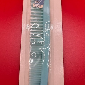May include: A blue plastic comb with the words "Silk'n Smooth" and "Tress" on the packaging. The packaging also says "Unbreakable in normal use" and "A new comb free if it breaks".