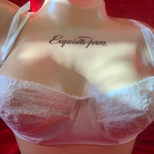May include: White lace bra with delicate floral embroidery and adjustable straps. The bra has a padded cup and a smooth, seamless back. The brand name "Exquisite Form" is printed on the front.