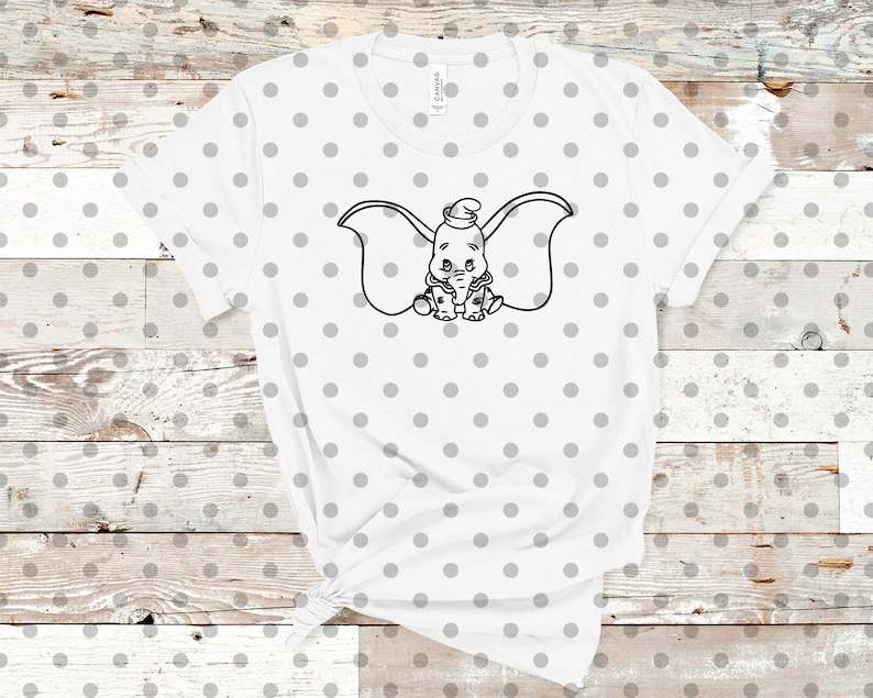 May include: White t-shirt with a black and white outline of Dumbo the elephant with big ears. The shirt has a white background with small gray polka dots.