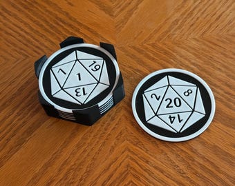 May include: Black and white D20 dice-shaped coasters. One coaster is stacked with others, and another is separate. The coasters have white numbers on a black background, with a white geometric design. Great for tabletop gaming.