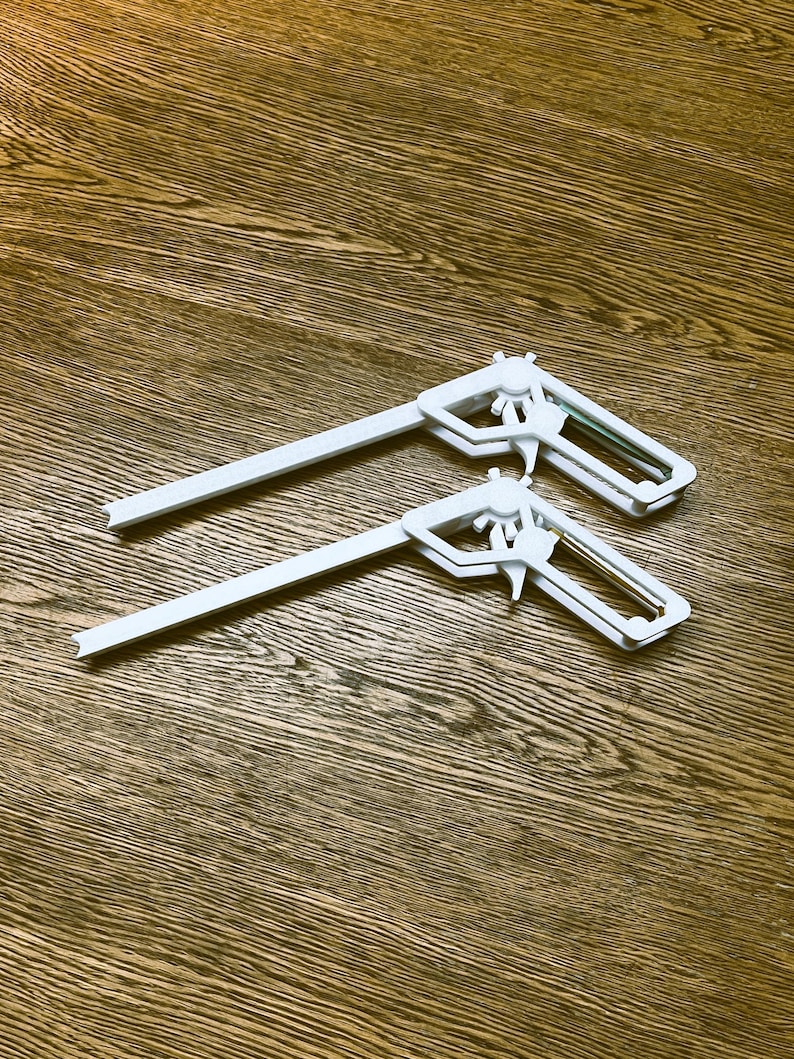May include: Two white plastic corner clamps, designed to hold pieces of wood together at a 90-degree angle.