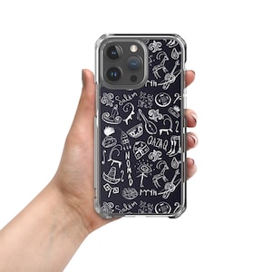 May include: A clear phone case with a black background and white doodles of various cultural symbols, including a hat, a musical instrument, a boot, and the words "Qazaq" and "Nomad".