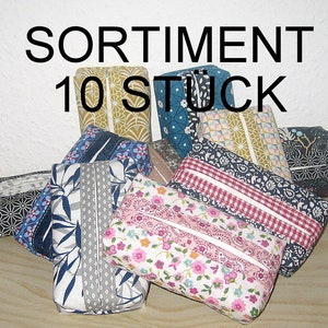 Könnte beinhalten: Sortiment von 10 Taschentuchbox-Bezügen in verschiedenen Mustern und Farben. Die Bezüge sind aus Stoff und haben eine Vielzahl von Designs, darunter florale, geometrische und abstrakte Muster. Die Bezüge sind alle rechteckig und haben eine Klappe, die sich öffnet, um Zugang zur Taschentuchbox zu ermöglichen.